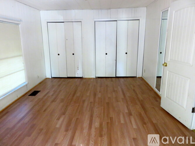 A room with wooden flooring and white doors.