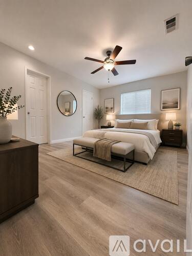 A bedroom with a bed, a ceiling fan, and a rug.