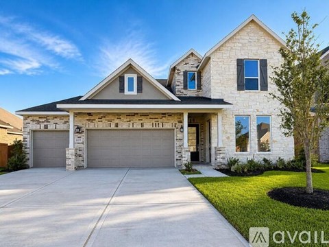 A two-story house with a garage and a tree in front.