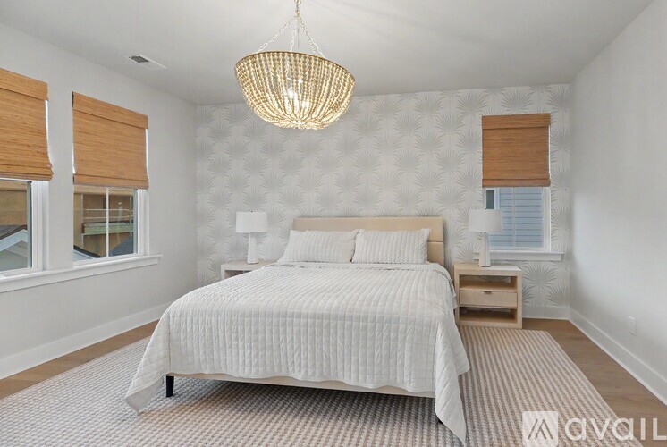 A bedroom with a large bed and a chandelier hanging from the ceiling.