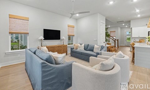 A living room with a grey sofa and a television on the wall.