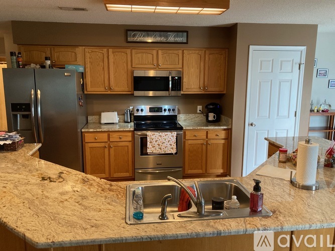A kitchen with granite countertops and wooden cabinets.
