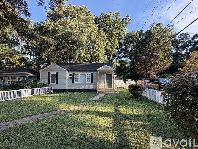 A house with a white picket fence in front of it.
