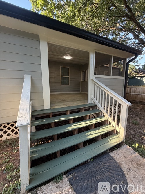 A small house with a green porch.