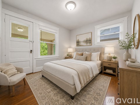 A bedroom with a large bed and a chair.