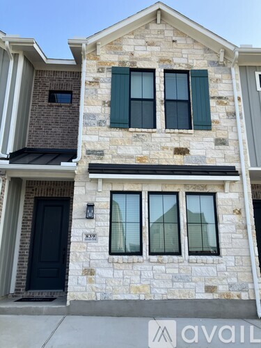 A two-story house with a black door and windows.