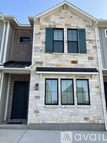 A two-story house with a black door and windows.