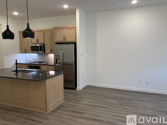 A kitchen with wooden cabinets and a black countertop.