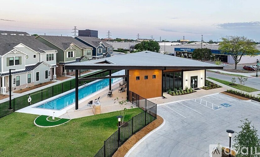 A swimming pool is surrounded by a fence and a grassy area.
