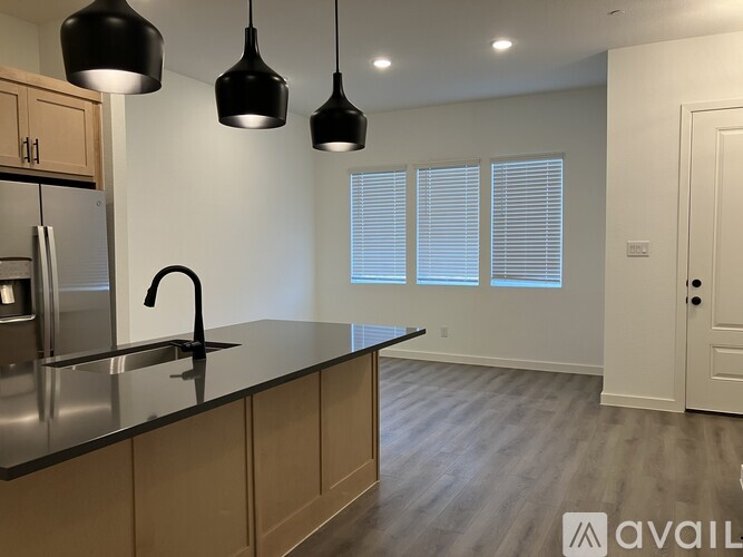 A kitchen with a black granite countertop and wooden cabinets.