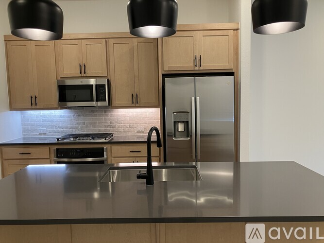 A kitchen with a stainless steel sink and refrigerator.
