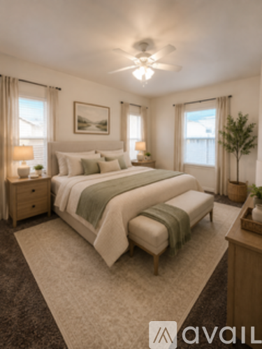 A bedroom with a large bed and a ceiling fan.
