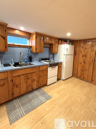 A kitchen with wooden cabinets and a white refrigerator.