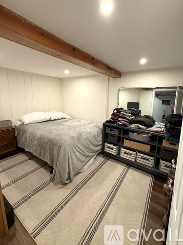 A bedroom with a bed, a dresser, and a mirror.