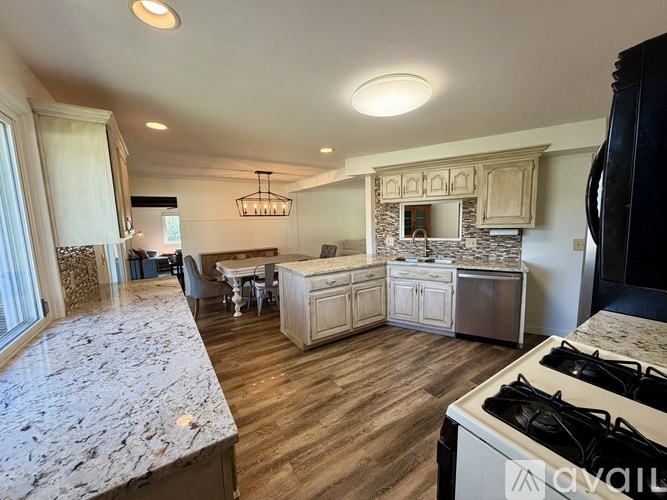 A kitchen with a marble countertop and wooden flooring.