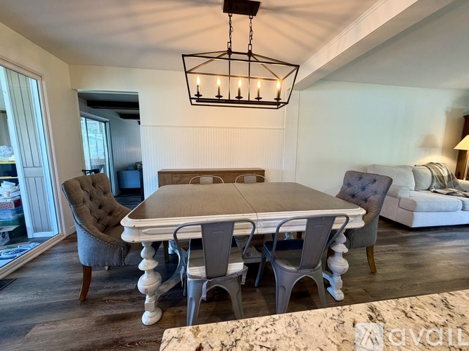 A dining room with a table and chairs.