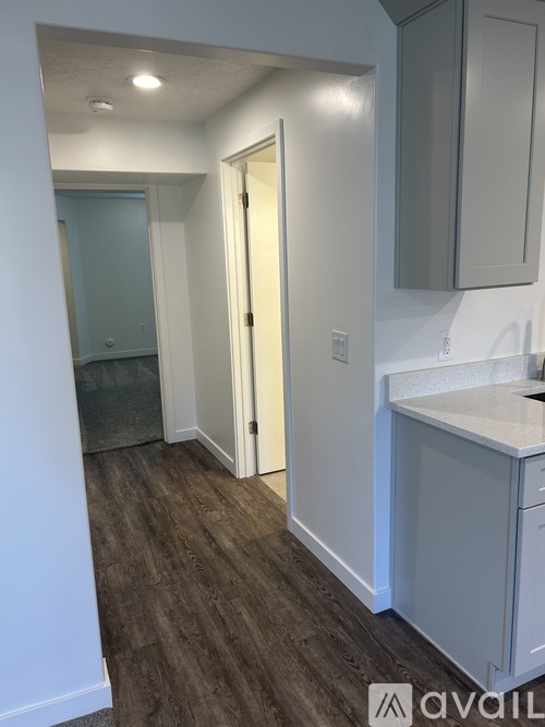 A kitchen with a white counter top and grey cabinets.