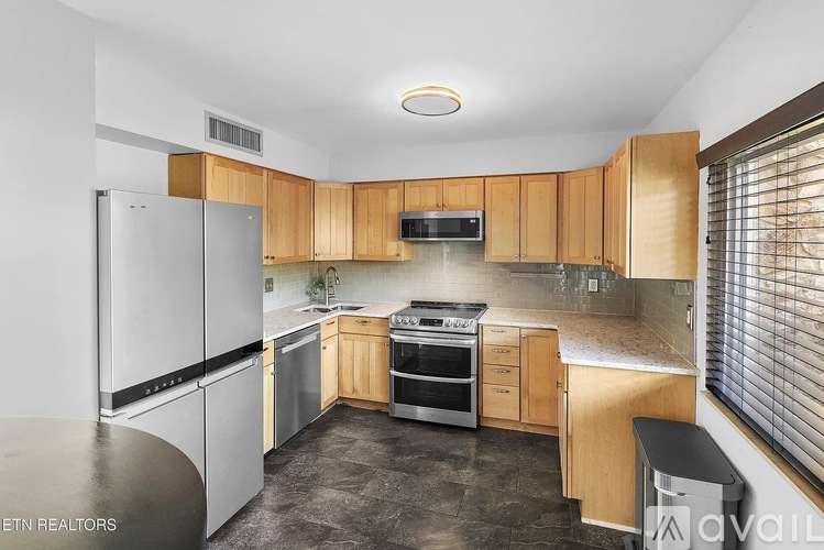 A kitchen with wooden cabinets and stainless steel appliances.