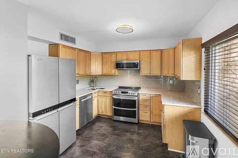 A kitchen with wooden cabinets and stainless steel appliances.