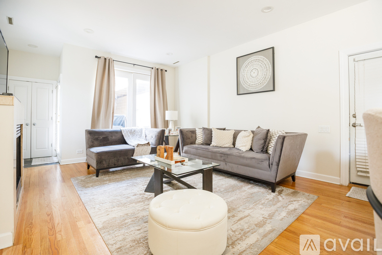 A living room with a grey couch, a coffee table, and a rug.