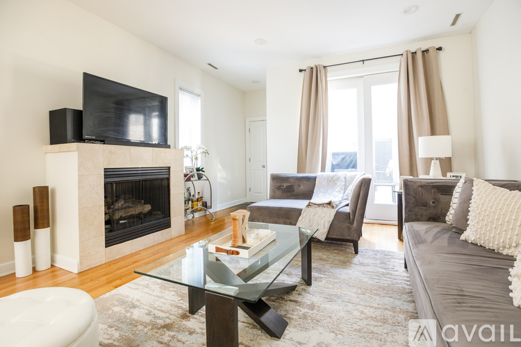A modern living room with a fireplace and a glass coffee table.