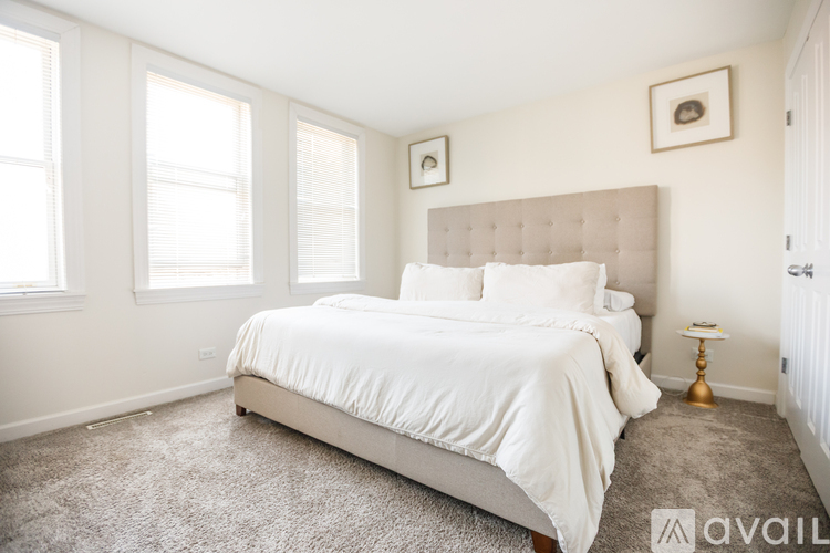 A bedroom with a large bed and a carpeted floor.