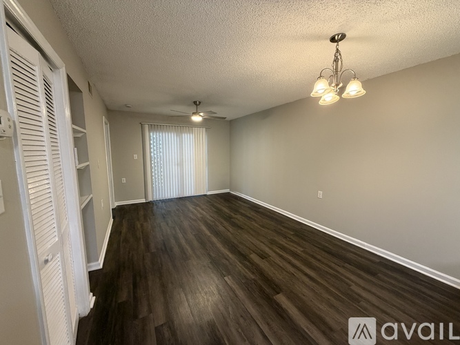A room with wooden floors and a chandelier.