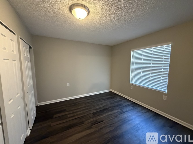 A room with a white door and a window with blinds.
