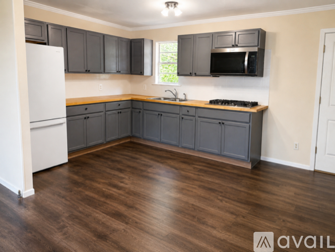 A kitchen with wooden floors and a white refrigerator.