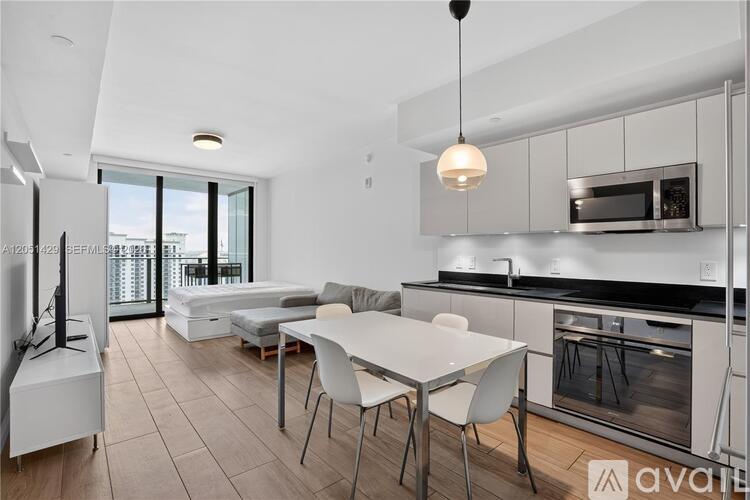 A modern kitchen with a dining table and chairs.