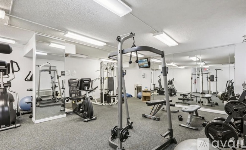 A gym with a variety of equipment including weights and cardio machines.