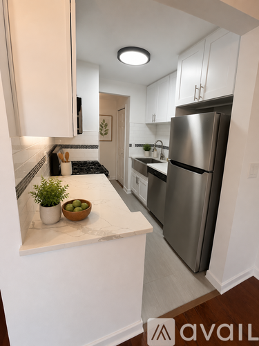 A kitchen with a refrigerator, stove, and countertop.