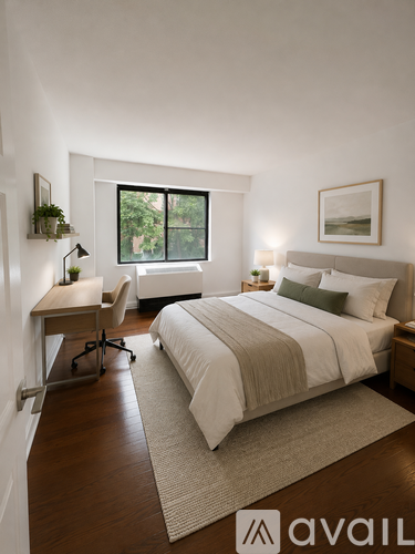 A bedroom with a large bed, a desk with a chair, and a window with a view of trees.