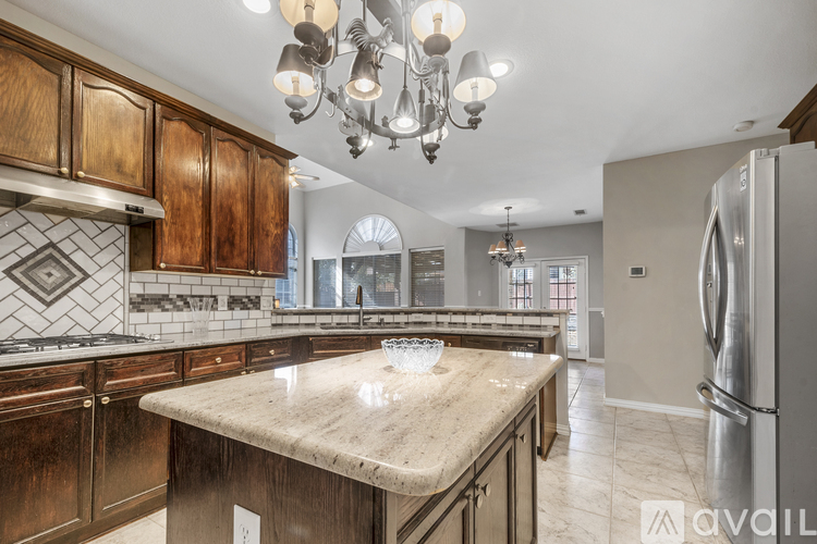A kitchen with wooden cabinets and a marble countertop.