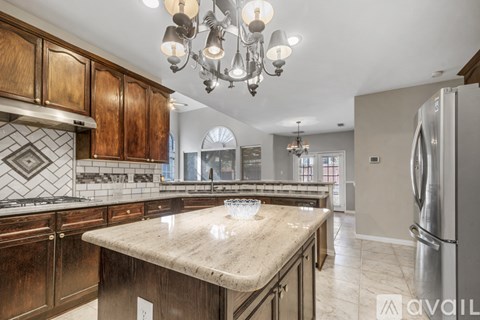 A kitchen with wooden cabinets and a marble countertop.