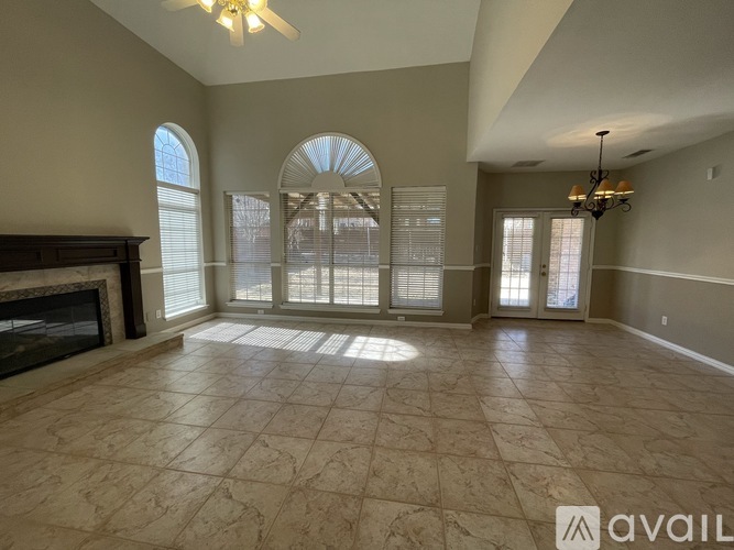 A spacious living room with a fireplace and large windows.