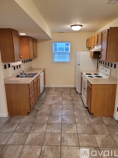 A kitchen with a white fridge and a window.