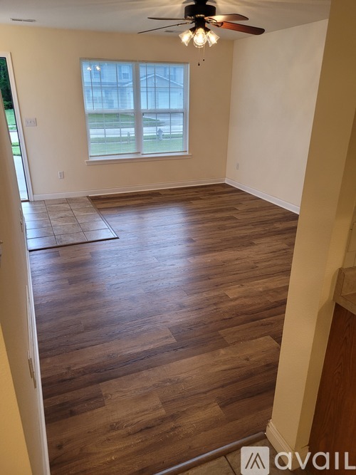 A room with wooden flooring and a ceiling fan.