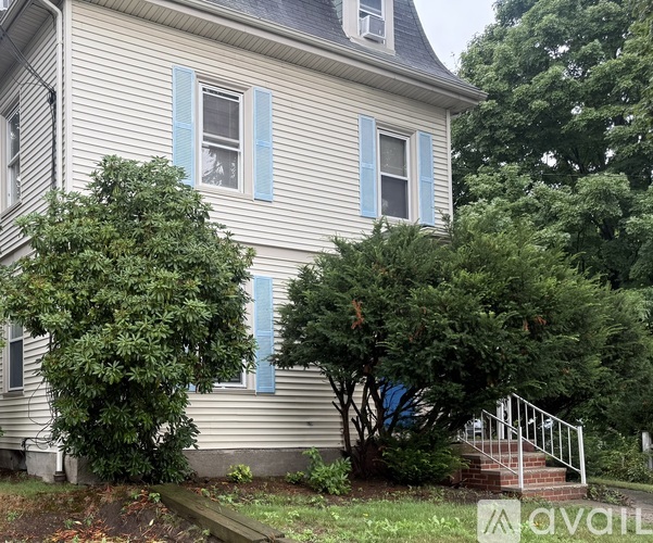 A house with blue shutters and a white fence.