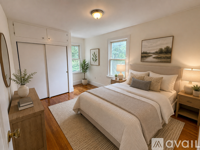 A bedroom with a large bed, a wooden nightstand, and a painting on the wall.