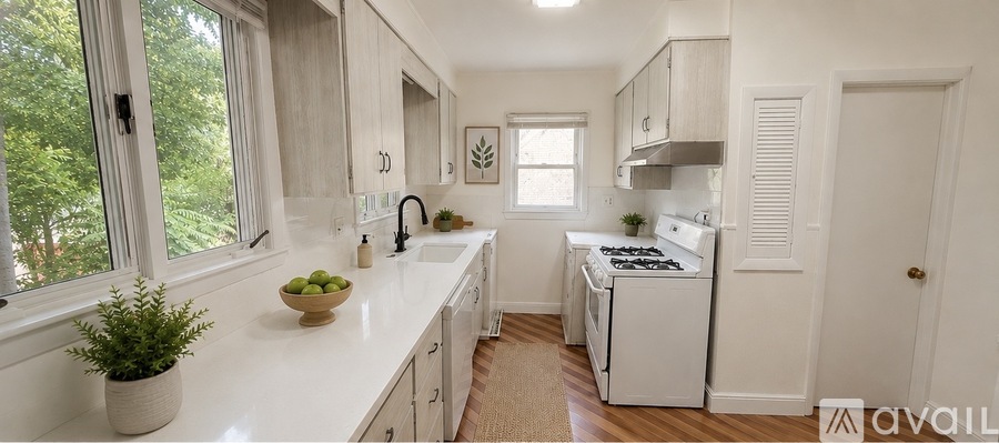 A kitchen with white cabinets and a white stove.