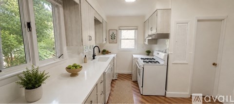 A kitchen with white cabinets and a white stove.