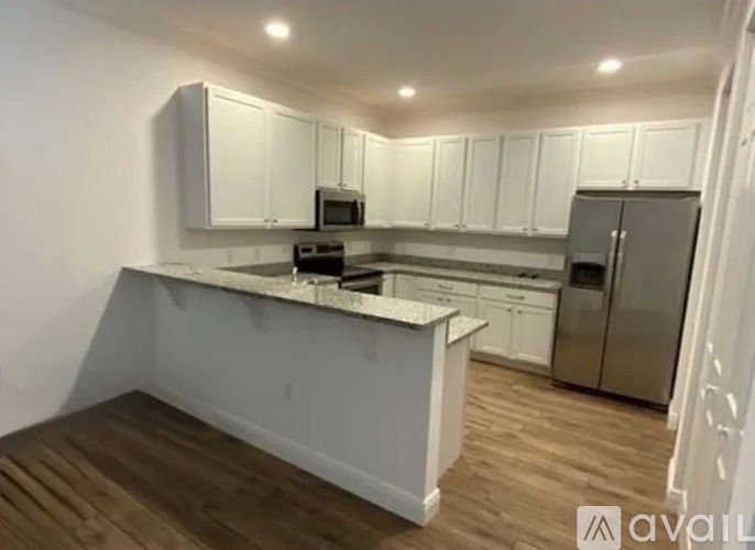 A kitchen with white cabinets and a wooden island.