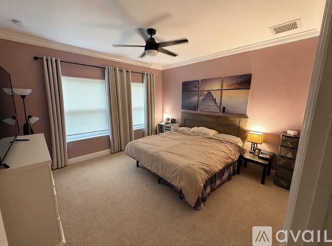 A bedroom with a bed, nightstand, and a ceiling fan.