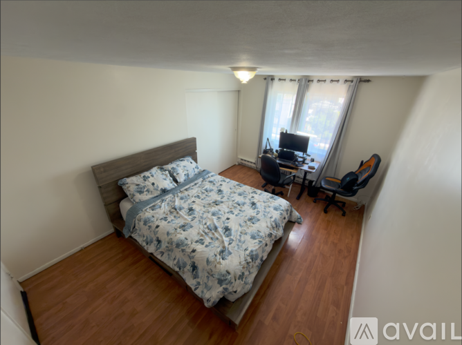 A bedroom with a bed, desk, and chair.