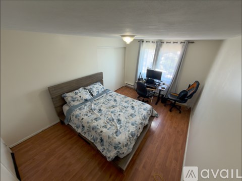 A bedroom with a bed, desk, and chair.