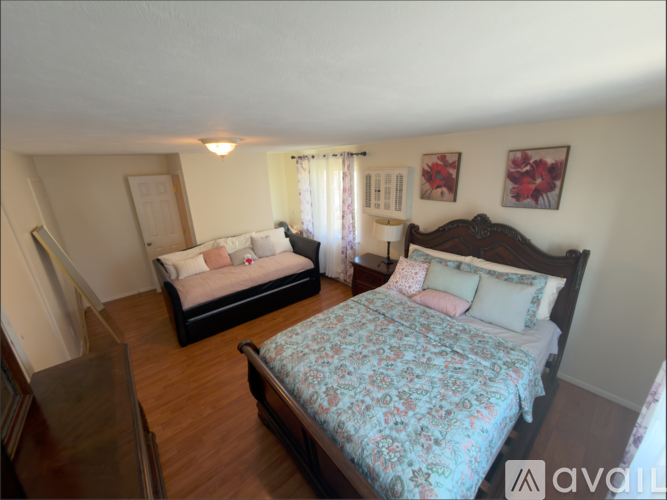 A bedroom with a large bed and a smaller bed in the corner.