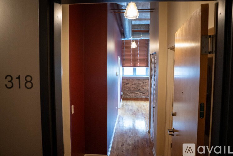 A hallway with a red door and a sign that says 318.