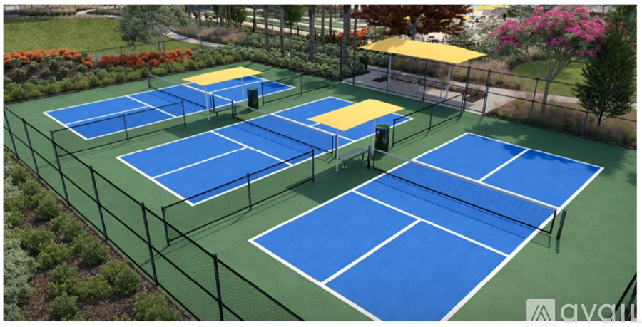 A tennis court surrounded by a fence and some trees.