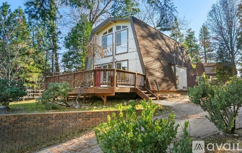 A house with a porch surrounded by trees.